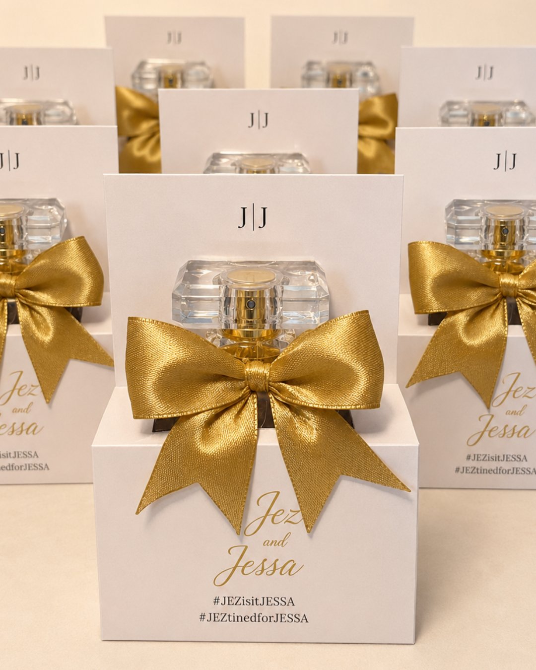 White gift boxes finished with gold bows holding 30ml premium perfume sprays, the Premium package keepsake